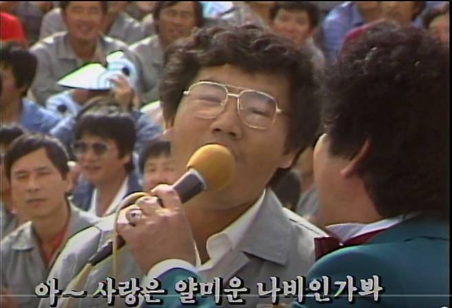 1987년 KBS가 방송한 가요무대 리비아 사리르 건설현장 공연 모습. 가수 현철과 근로자가 '사랑은 나비인가봐'를 함께 부르고 있다. /KBS유튜브캡처