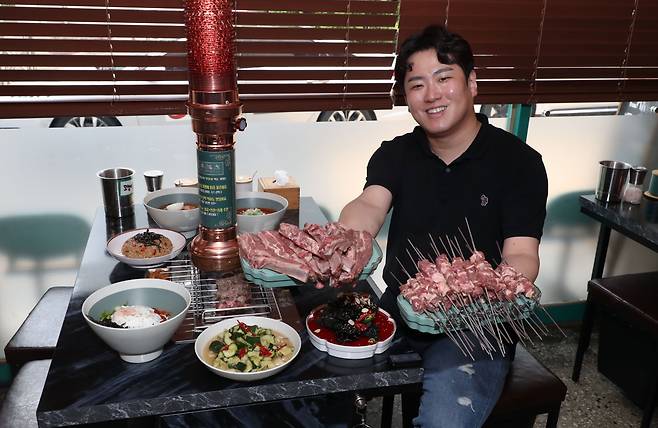 지난 9일 서울 성동구 양꼬치 전문점 '양복점' 성수점에서 송요섭 대표가 양꼬치와 블랙 꿔바로우를 들고 있다./전기병 기자