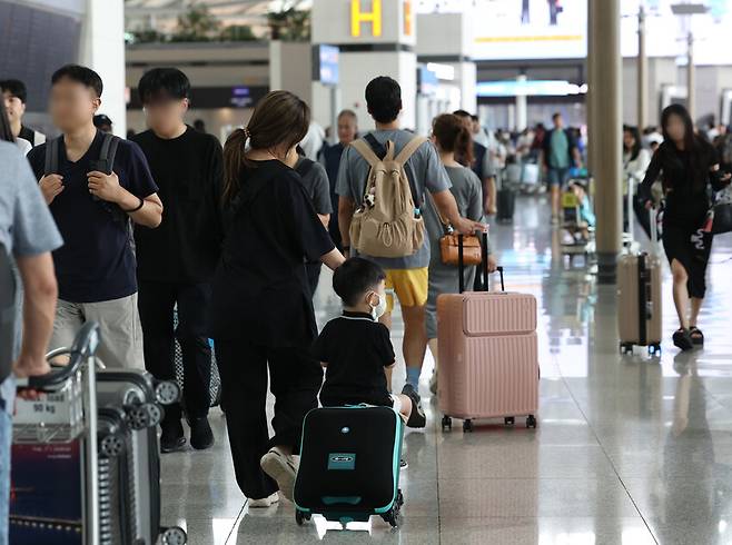 본격적인 휴가철을 맞은 지난달 28일 인천국제공항 제1터미널 출국장에서 한 어린이가 캐리어에 앉아 이동하고 있다. 연합뉴스