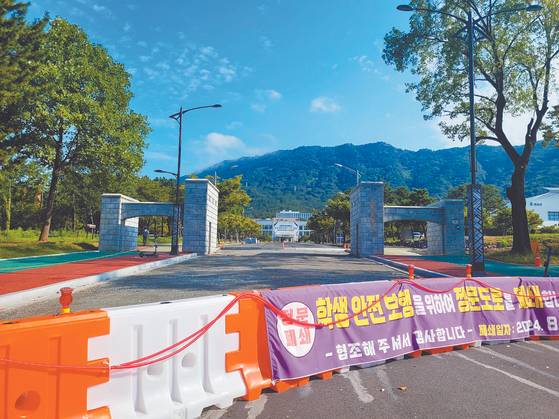 A sign reads that Changwon National University will be restricting access of cars through its main gate. [JOONGANG ILBO]