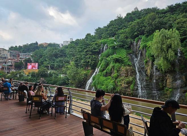 홍제천 인공폭포는 서울 서대문구가 자랑하는 글로벌 '폭포멍' 명소다. 야외 테라스에는 폭포를 배경으로 사진이나 영상을 촬영하는 외국인이 많다. /박돈규 기자