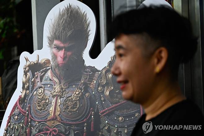 비디오 게임 '오공' 캐릭터 옆에 서있는 여성 [AFP 연합뉴스]