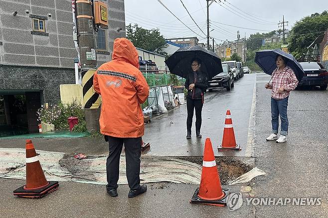 지난 6월 장맛비에 파인 도로 안전 조치하는 소방 [여수소방서 제공. 재판매 및 DB 금지]