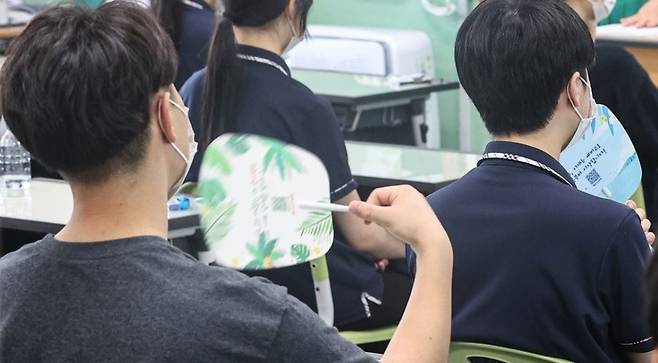 더위를 견디기 위해 부채질을 하며 수업을 듣는 학생 [연합]
