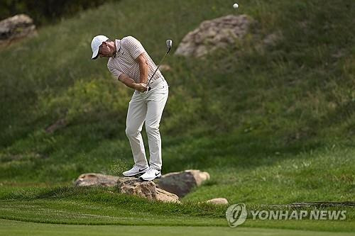 BMW챔피언십 1라운드 때 바위 위에서 스윙하는 매킬로이. [AP=연합뉴스]