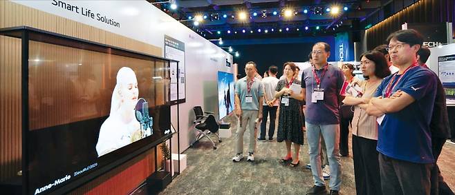 26일 서울 마곡동 LG사이언스파크에서 열린 ‘LG 테크페어’에서 직원들이 LG전자의 세계 최초 77인치 투명 올레드(OLED) TV를 살펴보고 있다.  LG 제공