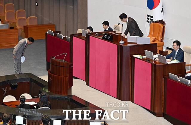 입장했던 반대 방향으로 퇴장하는 유상범 국민의힘 의원(왼쪽).