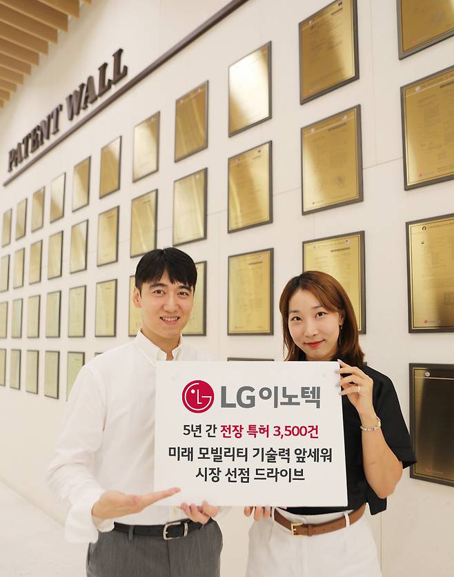 LG이노텍의 주요 특허를 명판에 새겨 전시한 기념 공간인 '페이턴트 월'(Patent Wall) 앞에서 직원들이 전장 특허 성과를 소개하고 있다. / 사진 = LG이노텍 제공