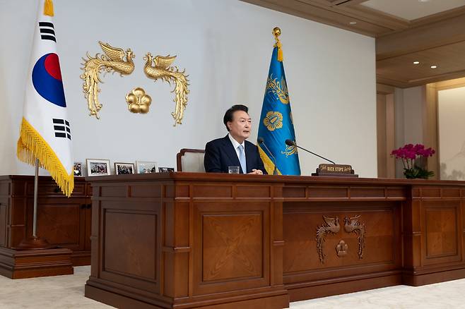 윤석열 대통령이 29일 서울 용산 대통령실 청사 집무실에서 국정브리핑을 하고 있다. 윤 대통령 뒤로 그가 군인, 소방관, 상인 등과 함께 찍은 사진 액자가 놓여 있다. /대통령실