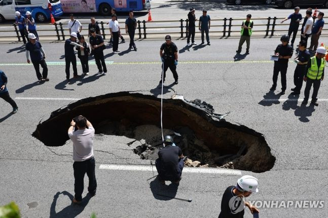 29일 오전 서울 서대문구 연희동 성산로에서 발생한 땅 꺼짐(싱크홀) 현상 현장에서 경찰 및 소방 관계자들이 사고 폭을 측정하고 있다.ⓒ연합뉴스