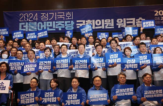 더불어민주당 이재명 대표와 박찬대 원내대표 등이 29일 영종도 네스트호텔에서 열린 2024 정기국회 국회의원 워크숍에서 피켓을 들고 단체 사진을 찍고 있다.