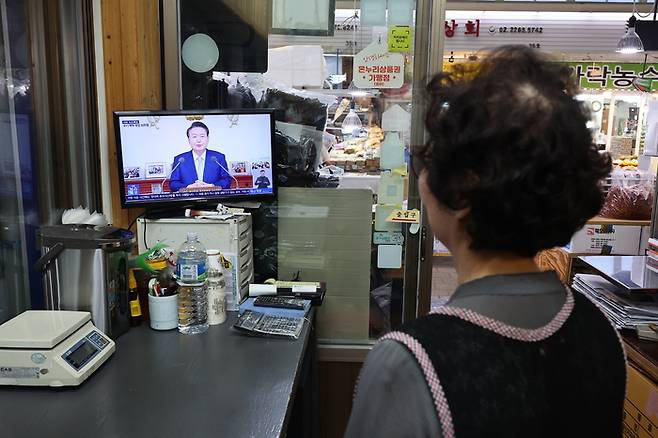 29일 오전 서울 시내 한 전통시장에서 상인이 윤석열 대통령의 국정브리핑 및 기자회견 중계방송을 지켜보고 있다. 연합뉴스.