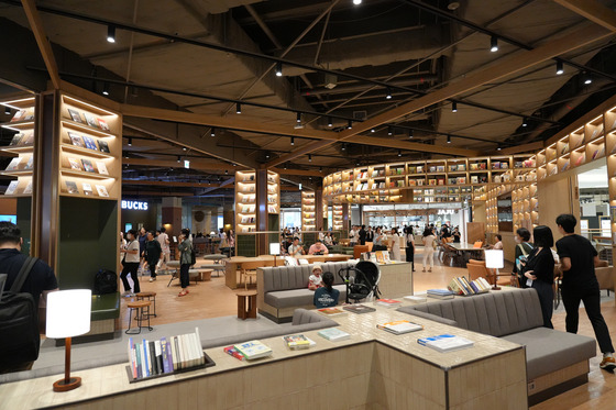 Book Ground, a smaller version of the Starfield Library seen on the larger Starfield shopping complex branch in Coex and Suwon, located at the center of the Starfield Market Emart Jukjeon in Yongin, Gyeonggi. The Book Ground is accompanied by a Starbucks cafe — the largest Starbucks inside any Emart branch — followed by a spacious open seating area surrounding it. [CHO YONG-JUN]