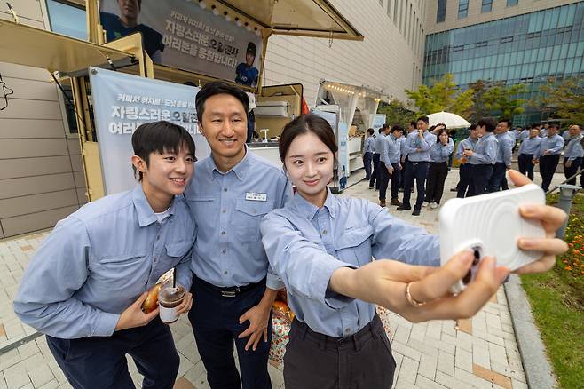 직원 격려하는 정기선 부회장 지난 26일 HD현대오일뱅크 대산공장을 찾은 정기선 HD현대 부회장(가운데)이 직원들과 함께 '셀카'를 찍고 있다. 정 부회장은 이날 무더운 날씨에 일하는 임직원·협력사 직원 2400여 명에게 커피와 도넛을 직접 나눠주는 한편 대산공장 내 주요 생산설비를 둘러보며 현장 직원들을 격려했다.  HD현대