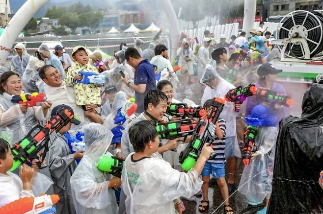 지난해 축제 때 남천교 위에서 열린 ‘물벼락 페스티벌’에서 참가자들이 신나는 음악에 맞춰 즐겁게 물총싸움을 벌이고 있다. 올해는 축제 첫날인 31일과 9월 1일, 7, 8일 매일 오후 2시부터 1시간 동안 총 4차례에 걸쳐 진행한다. 무주군 제공