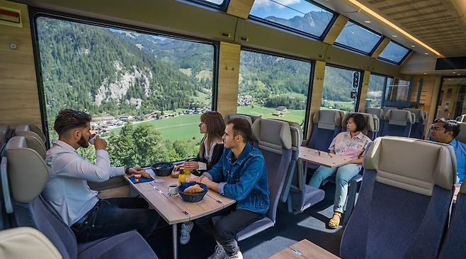 미드나잇 블루 색상을 활용한 기차에는 바닥부터 천장까지 이어지는 유리창이 있다