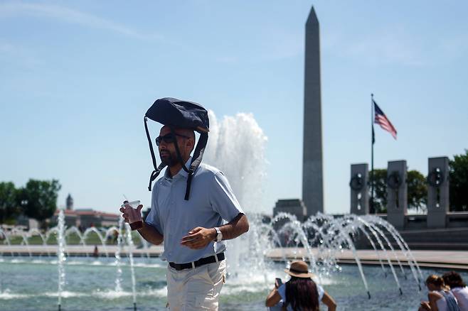 지난 7월 미국 워싱턴 DC에서 한 사람이 태양을 피하려고 시도하고 있다./EPA 연합뉴스
