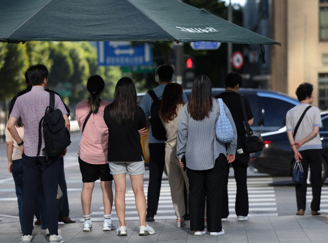 지난 30일 오전 서울 광화문사거리에서 시민들이 횡단보도 신호가 바뀌기를 기다리고 있다. 연합뉴스