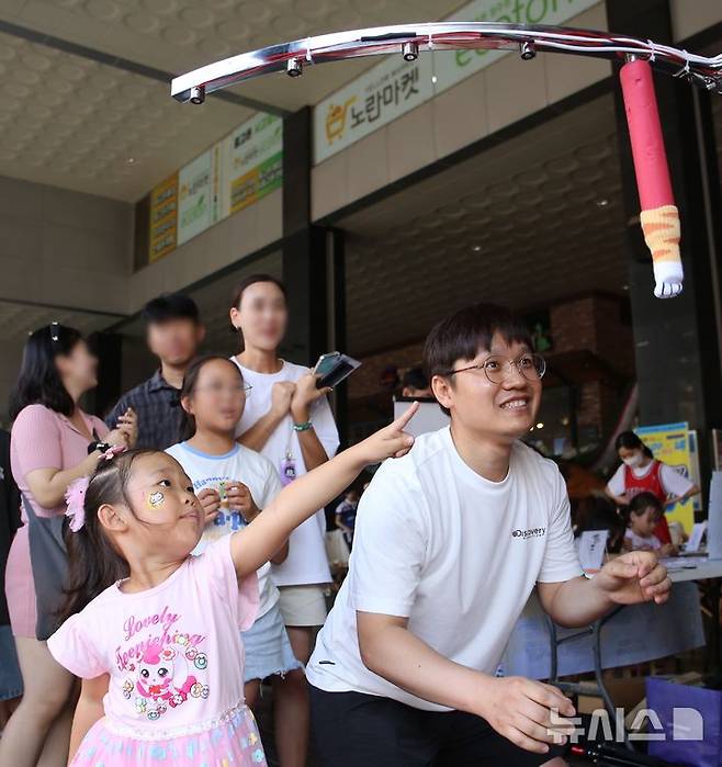 [청주=뉴시스] 서주영 기자 =  청주원도심골목길축제 '성안이즈백' 행사가 31일 오후 청주시 상당구 성안길 일대에서 열렸다. 시민들이 행사 게임코너에서 떨어지는 스틱을 잡는 게임인 '드랍스틱'을 즐기고 있다. 2024.08.31. juyeong@newsis.com