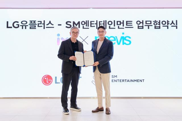 정수헌(왼쪽) LG유플러스 컨슈머부문장과 탁영준 SM 공동대표가 지난달 29일 서울 성수동 SM 사옥에서 업무협약식 후 기념촬영을 하고 있다. LG유플러스 제공