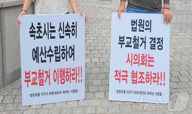 속초·고성·양양환경운동연합과 '영랑호를 지키기 위해 뭐라도 하려는 사람들'이 2일 강원 속초시청 앞에서 부교 철거 신속 이행을 촉구하는 피켓시위를 열고 있다.(속초·고성·양양환경운동연합 제공) 2024.9.2/뉴스1