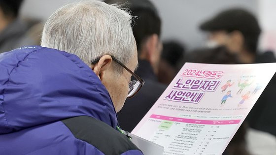 지난해 12월 열린 ‘2023 마포구 노인 일자리 박람회’에서 한 노인이 일자리 목록을 살펴보고 있다. [연합뉴스]