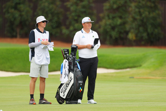 Im Sung-jae talks with his caddie Will Wilcox on the seventh hole during the final round of the Tour Championship at East Lake Golf Club in Atlanta, Georgia on Sunday.  [GETTY IMAGES]