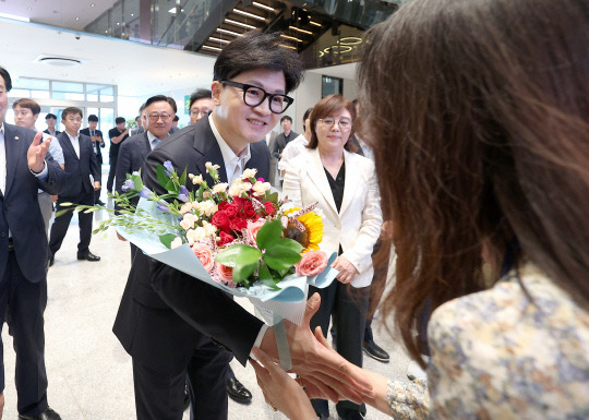 한동훈 국민의힘 대표가 3일 오후 경북 구미시 산동읍에 위치한 반도체 소재·부품 전문기업인 원익큐엔씨를 방문해 업체 직원으로부터 꽃다발을 받고 있다. [연합뉴스 제공]