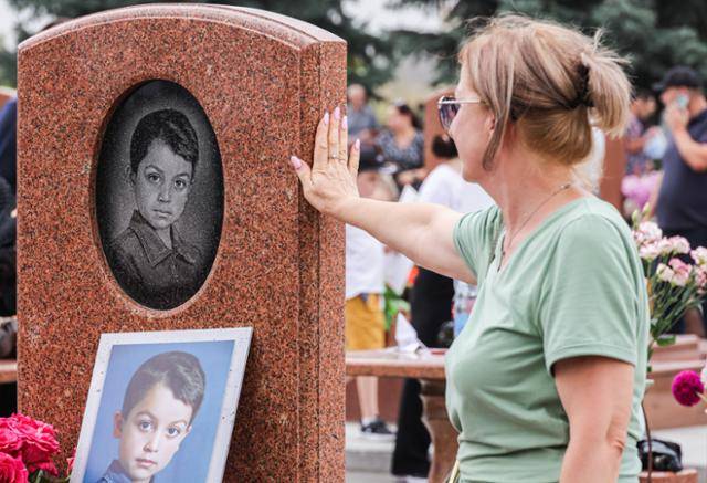 러시아 북오세티야 공화국에 위치한 베슬란 제1공립학교 인질 사건 20주년을 맞은 3일 한 추모객이 당시 희생자 266명이 잠들어 있는 천사의 도시 묘지를 방문해 묘비를 어루만지고 있다. 베슬란 학교 인질 사건은 러시아 최악의 테러 중 하나로 체첸 이슬람 반군이 인질로 잡은 학생과 교사 등 1,200여 명을 구출하는 과정에서 폭발, 총격전, 체육관 지붕 붕괴 등으로 어린이 186명을 포함해 300여 명 이상이 목숨을 잃었다. 베슬란=타스 연합뉴스