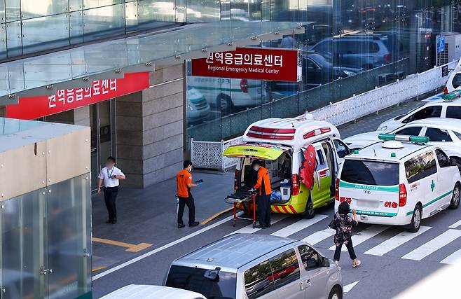 Emergency rescue workers and ambulances are seen outside the emergency medical center at a university hospital in Seoul on Tuesday. (Yonhap)