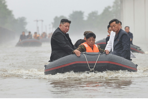 North Korean leader Kim Jong-un, left, inspects flooded areas in Sinuiju, a border city in North Pyongyan Province, following heavy rainfall earlier in the week in a photo carried by its official Korean Central News Agency in August. [YONHAP]