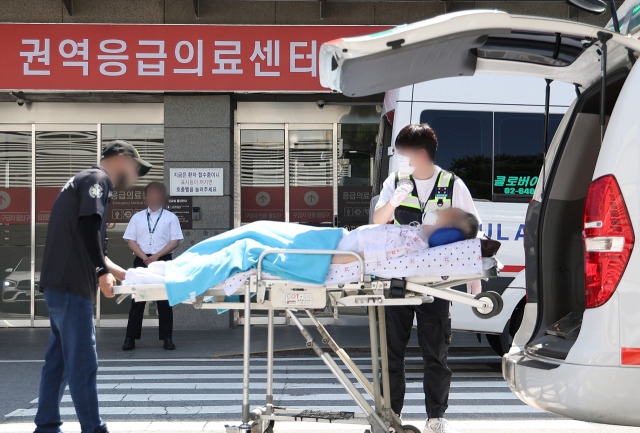 전국 곳곳에서 응급실 운영이 파행하는 가운데 정부가 4일 군의관 등 보강 인력을 긴급 배치했다. 이날 서울 양천구 이화여대목동병원 응급의료센터 인근에서 한 환자가 이송되고 있다. 연합뉴스