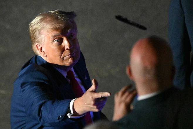 2024년 9월 4일, 펜실베이니아 해리스버그의 뉴 홀랜드 아레나에서 폭스 뉴스 방송인 션 해니티가 진행하는 타운홀 미팅 후, 도널드 트럼프 전 미국 대통령이 사인을 마친 후 청중에게 펜을 던지고 있다. AFP 연합뉴스