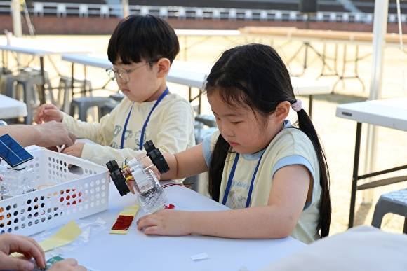 '반디 폐품&재활용' 경진대회 참가 어린이들이 페트병으로 재활용품을 만들고 있다. [사진=무주군]