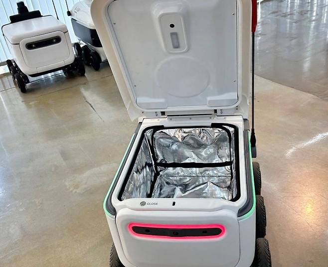 로봇을 열면 나오는 공간에 음식을 넣고 배달에 나서는 배송로봇 / 출처=IT동아