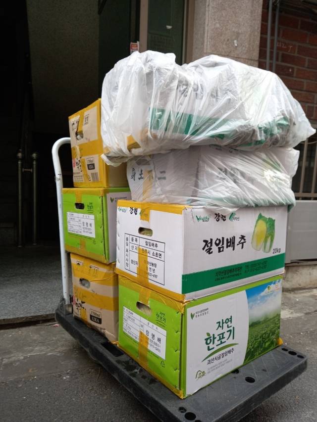 ‘목사님의 택배일기’ 저자가 택배기사로 일할 당시 배송한 ‘공포의 절임 배추’ 상자들. 내용물이 샐 거 같은 상자는 비닐로 포장 후 손수레 맨 위에 올려 더 이상의 파손을 막았다. 산지니 제공