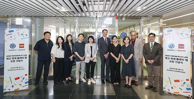 정희영 레고코리아 대표(왼쪽에서 일곱 번째), 소렌 모럽 레고코리아 마케팅 상무(왼쪽에서 여섯 번째), 김현경 연세대학교 생활과학대학 교수(왼쪽에서 다섯 번째), 김석경 연세대학교 생활과학대학장(왼쪽에서 여덟 번째), ‘Y-LEGO’ 연구진이 기념 촬영을 하고 있다. / 사진 = 레고코리아