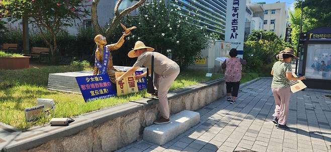 일본군 위안부 피해자 소녀상에 혐오 문구 팻말 설치하는 남성 [경남도교육청 제공. 재판매 및 DB 금지]