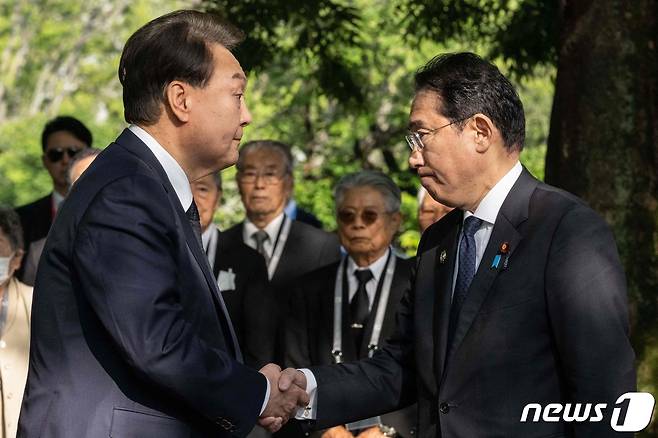 주요 7개국(G7) 정상회의 참관국 자격으로 일본을 방문 중인 윤석열 대통령이 21일 오전 일본 히로시마 평화기념공원에 있는 한국인 원폭 희생자 위령비 참배에 앞서 기시다 후미오(岸田文雄) 일본 총리와 악수하고 있다. ⓒ AFP=뉴스1 ⓒ News1 최종일 기자