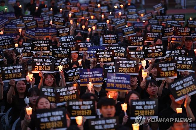 구호 외치는 선생님들 서울 서이초등학교 교사의 49재 추모일인 2023년 9월4일 오후 서울 서초구 서울교대에서 열린 촛불문화제에서 참가자들이 촛불과 피켓을 들고 구호를 외치고 있다. 
[연합뉴스 사진]