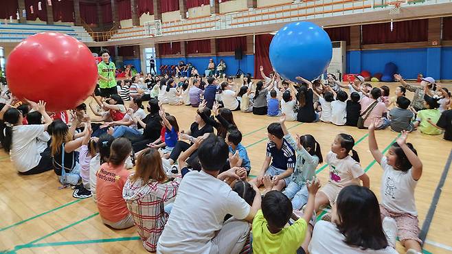 [서산=뉴시스] 지난 7일 서산중앙고등학교 체육관에서 열린 2024년 드림스타트 가족 운동회에 참가한 가족들이 큰 공 굴리기를 하고 있다. (사진=서산시 제공) 2024.09.08.  *재판매 및 DB 금지