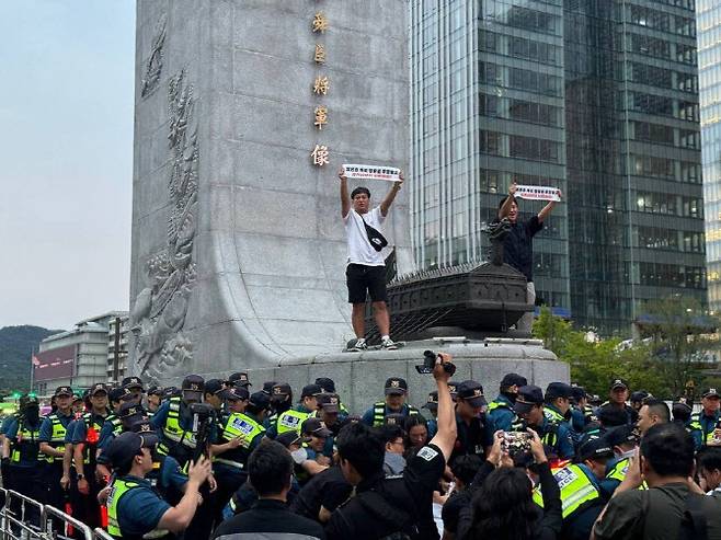 이순신 동상 위에서 기습시위하는 민주노총 조합원들.(사진=민주노총)