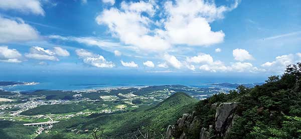 달음산 정상. 가운데 볼록 솟은 봉우리가 월음산이다.