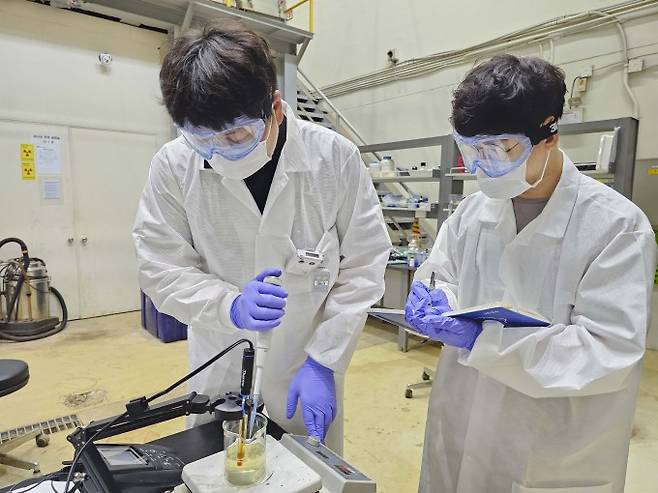 한국원자력연구원 연구팀이 용액에 녹아 있는 우라늄 회수를 위해 침전반응을 일으키는 첨가제를 주입하고 있다. 원자력연 제공