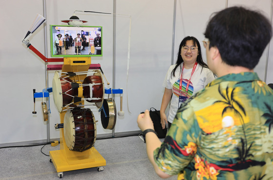 An attendee of the 2024 K-ICT Week tries out a virtual reality device that plays traditional Korean drums at the Bexco convention center in Busan on Tuesday. [YONHAP]