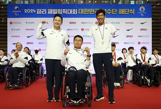 보치아 국가대표팀 임광태 감독(가운데)과 장애인 트라이애슬론 국가대표 김황태(오른쪽)가 10일 오후 인천국제공항 제2여객터미널에서 열린 2024 파리 패럴림픽 대한민국 선수단 해단식에서 순금 메달을 받은 뒤 기념 촬영을 하고 있다. [연합]