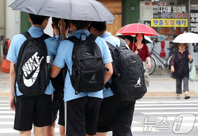 늦더위가 이어진 11일 오후 대구 중구 국채보상로 일대에 비가 내리자 하굣길 학생들이 우산 하나로 함께 비를 피하며 횡단보도를 건너고 있다. 2024.9.11/뉴스1 ⓒ News1 공정식 기자