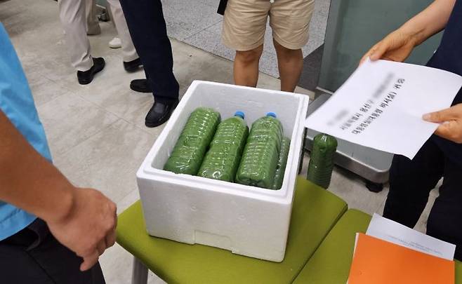 낙동강네트워크 등 경남 시민단체 및 정당이 서울 용산 대통령실에 보낼 녹조가 담긴 페트병을 담고 있다. [사진=이세령 기자]