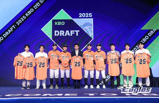 한화 손혁 단장과 프런트가 2025 KBO 신인 드래프트에서 지명한 선수들, 그리고 참가하지 못한 선수들의 유니폼과 함께 기념 촬영을 진행 중이다. 사진=한화 이글스 제공