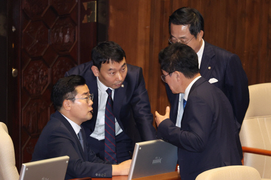 박찬대 ‘입에 펜뚜껑 물고’ 박찬대(왼쪽) 더불어민주당 원내대표가 12일 오후 서울 여의도 국회에서 열린 본회의에서 의원들과 상의하고 있다. 뉴시스